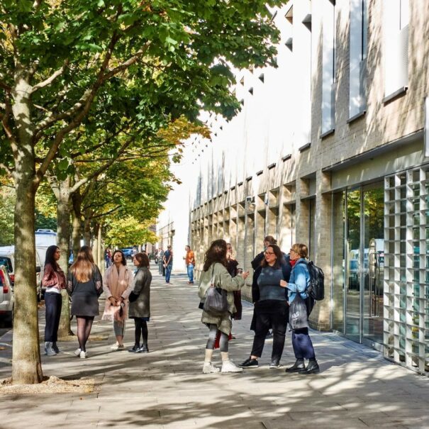 Groups of young people having conversations in a sunny urban environment