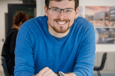 Concert Bio CEO Paul Rutten is pictured leaning on a desk and smiling.